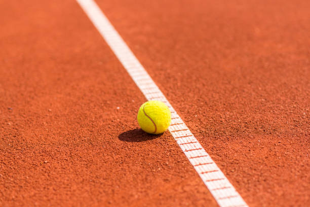 Préparation d’un court de tennis en terre battue à Louveciennes pour un tournoi